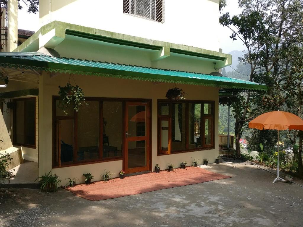 a house with an umbrella in front of it at The Woods in Nainital