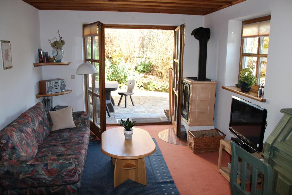 uma sala de estar com um sofá, uma televisão e uma mesa em Ferienwohnung Weinberger em Regen