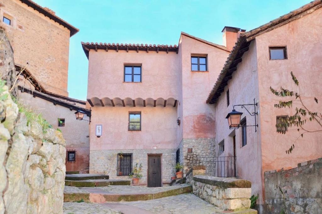 un antiguo edificio en un pueblo italiano con una acera de piedra en Apartamento Portal del Agua, en Albarracín