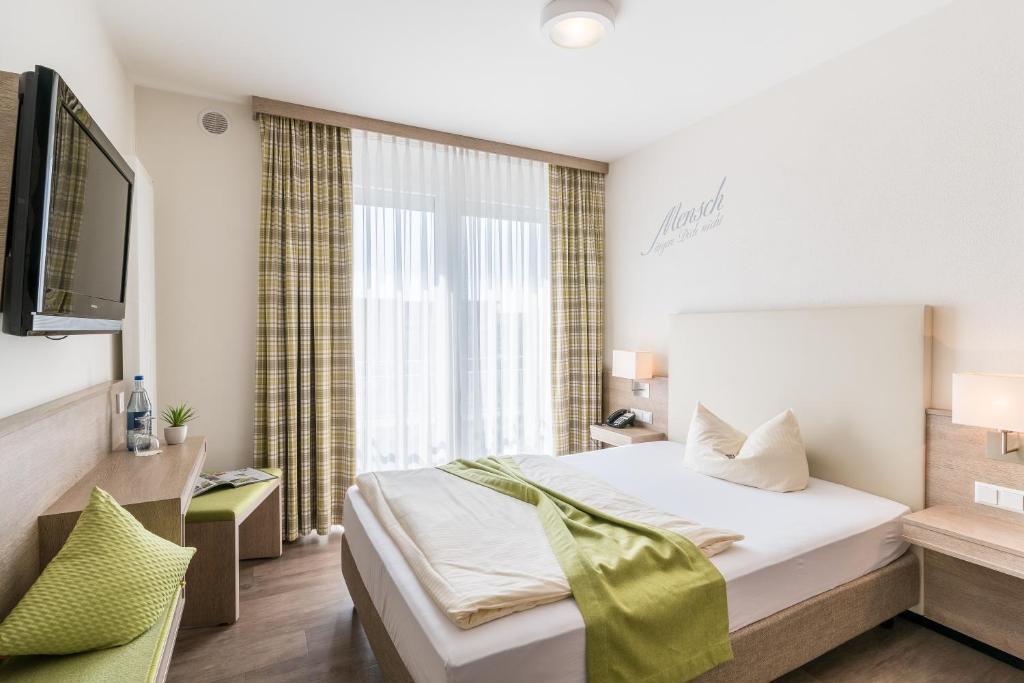 A bed or beds in a room at Parkhotel Pfarrkirchen