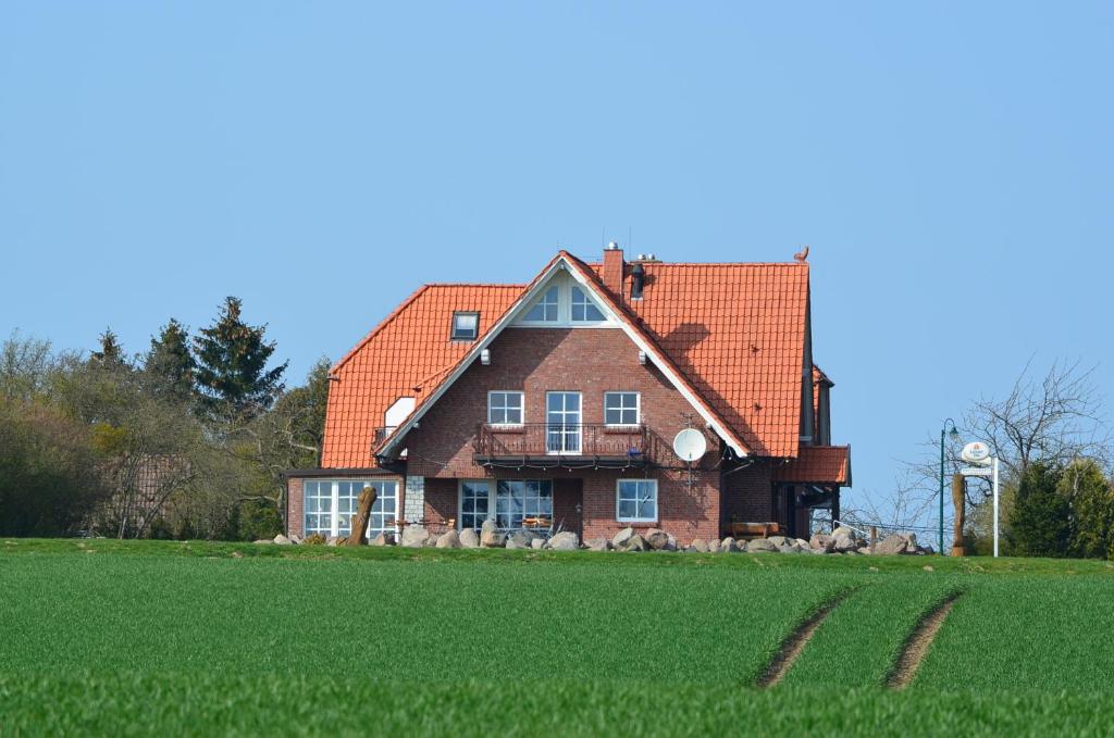 uma casa com um campo verde em frente em Landhaus Bondzio em Langen Brütz