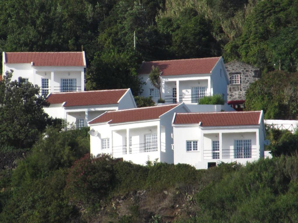 una fila de casas blancas en una colina en Aldeia da Encosta, en Velas