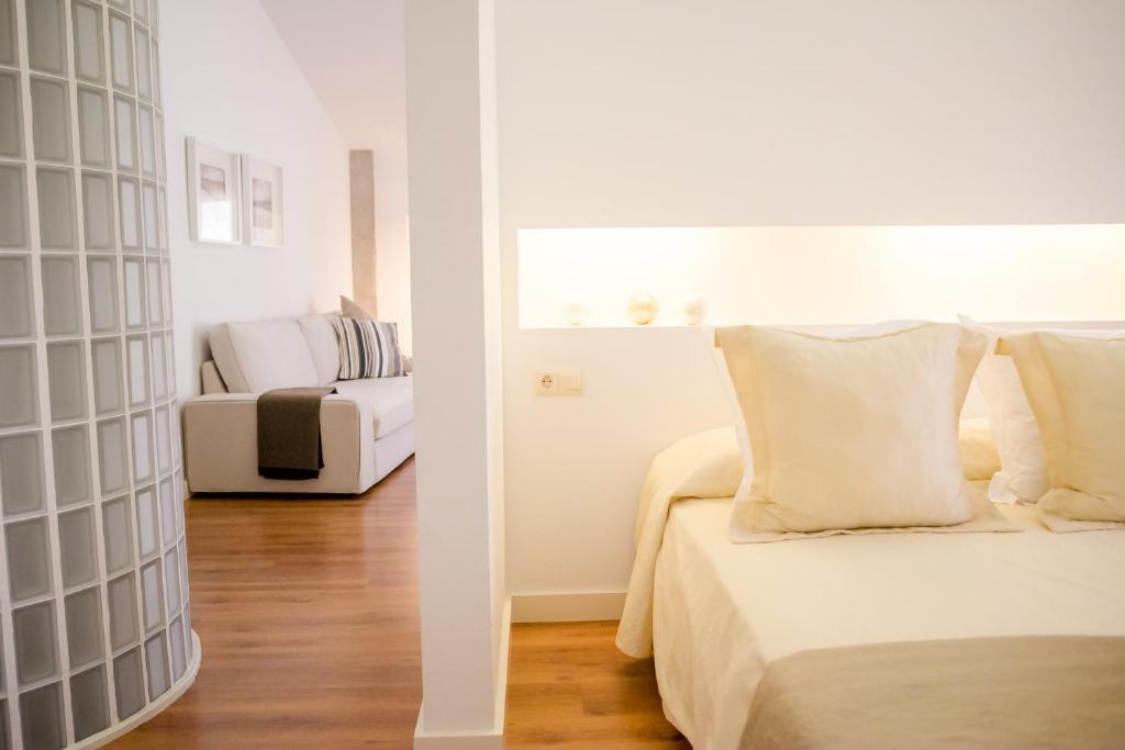 1 dormitorio con 1 cama y sala de estar con sofá en Alojamientos Don Alvaro, en Caravaca de la Cruz