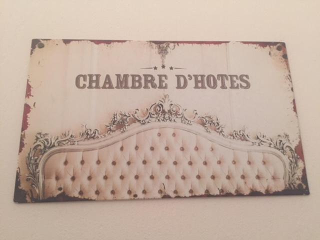 Ein Schild, auf dem steht, dass Chandra Dolores an einer Wand hängt. in der Unterkunft B&B Les Muscades in Saint-Étienne-du-Grès