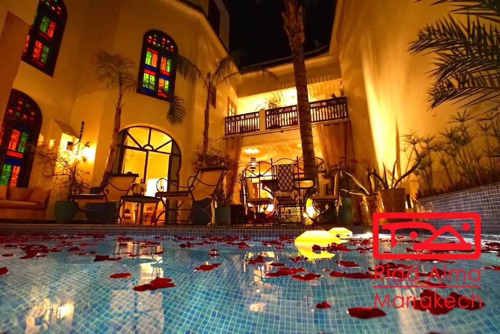 einen Pool mit roten Stühlen in einem Gebäude in der Unterkunft Riad Alma in Marrakesch