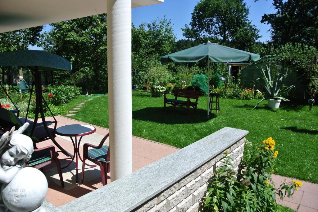 eine Terrasse mit einem Tisch, Stühlen und einem Sonnenschirm in der Unterkunft Haus Mantai in Freudenstadt