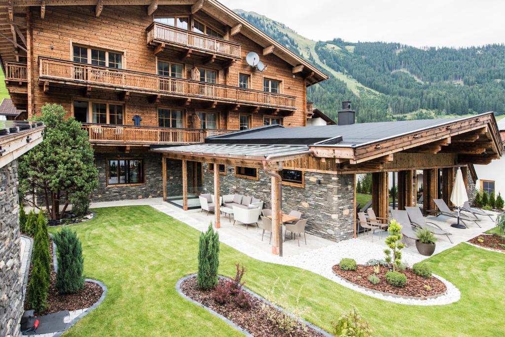 una imagen de una casa de madera con patio en Pepi's Suites - Lechtal Apartments, en Holzgau