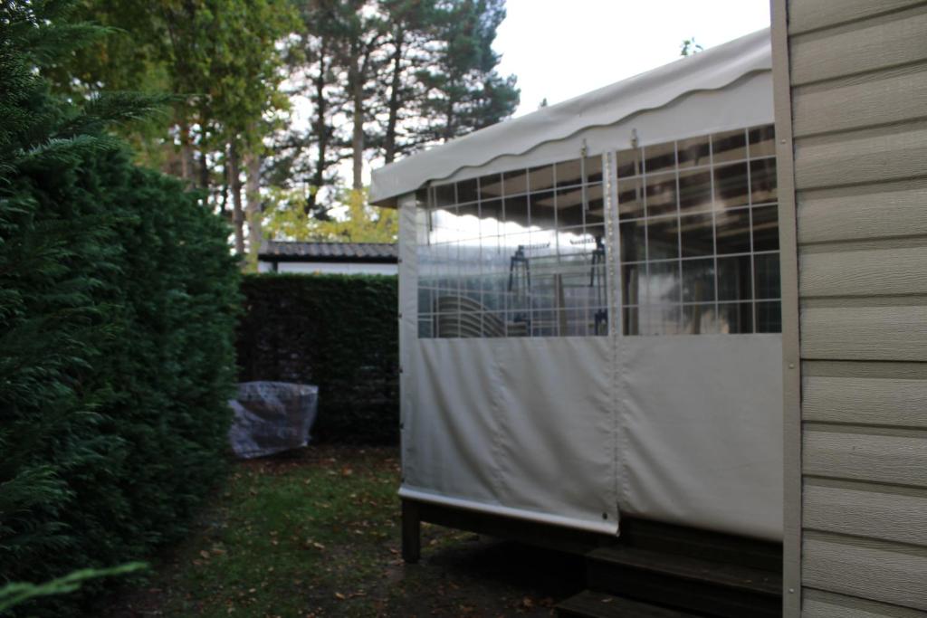 a bird cage in a garden with a person in it at Les mobiles Homes de la Palmyre in Les Mathes