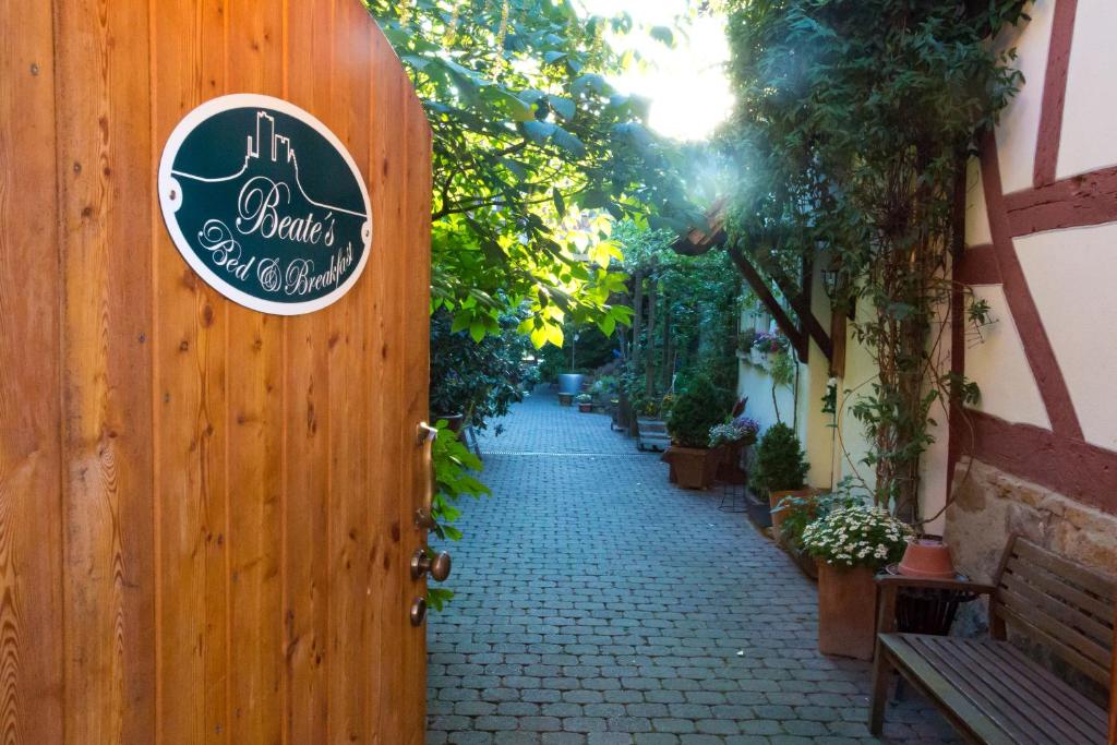 a sign on a wooden fence with a walkway at Beate's Bed & Breakfast in Münzenberg