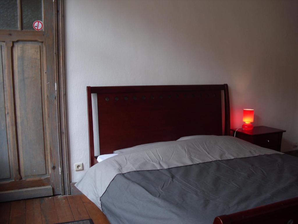 een slaapkamer met een bed en een rode lamp op een tafel bij Guesthouse Oude Houtmarkt in Ieper