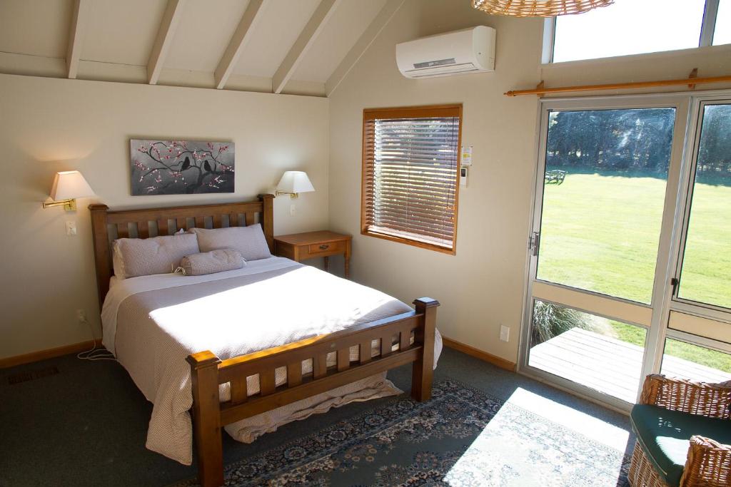 1 dormitorio con cama y ventana grande en Stronechrubie Accommodation and Restaurant, en Mount Somers