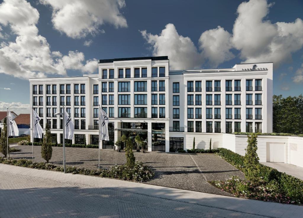 a white building with flags in front of it at Parkhotel Stuttgart Messe-Airport in Leinfelden-Echterdingen