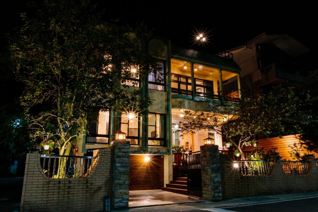 Una casa de noche con luces encendidas. en Nanchuang Wind Suzuki Coffee Houses, en Nanzhuang