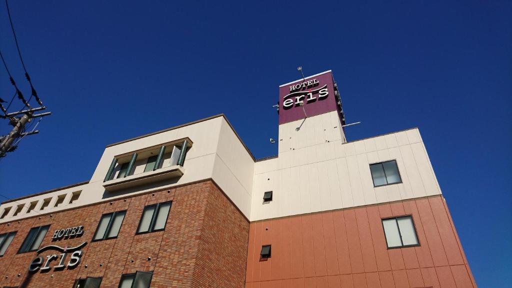 un bâtiment avec une tour d'horloge en haut dans l'établissement Hotel Eris Hakata (Love Hotel), à Fukuoka