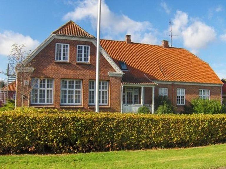 une grande maison en briques avec un toit orange dans l'établissement Motel Majbølle Gamle Skole, à Majbølle