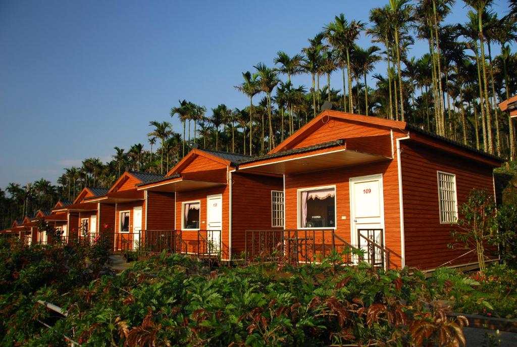 a row of houses with palm trees in the background at Ming Zhen Homestay in Gukeng