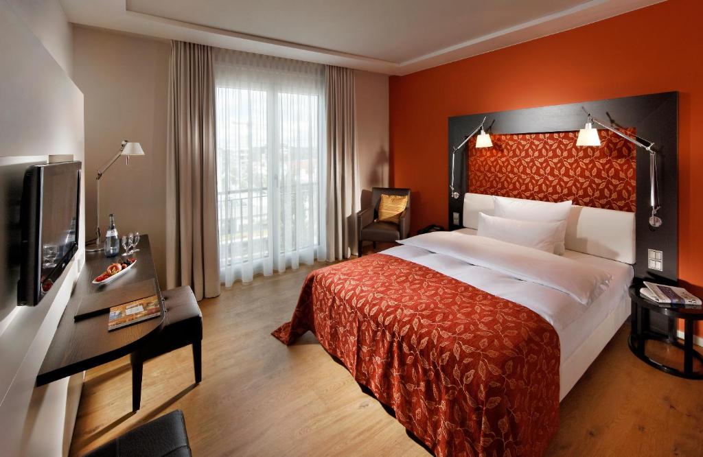 a hotel room with a bed and a television at Parkhotel Stuttgart Messe-Airport in Leinfelden-Echterdingen