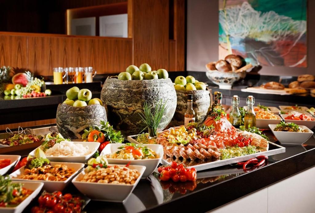 a buffet with many plates of food on a table at Parkhotel Stuttgart Messe-Airport in Leinfelden-Echterdingen