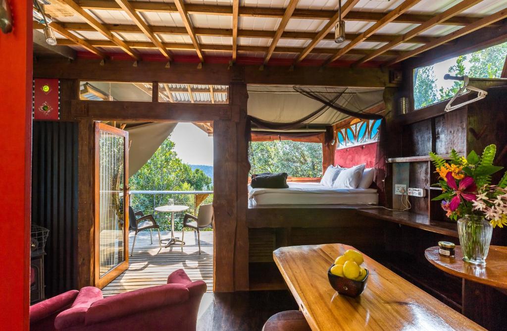a bedroom in a tree house with a bed and a table at Moonshine on Whiskey Creek in The Crags