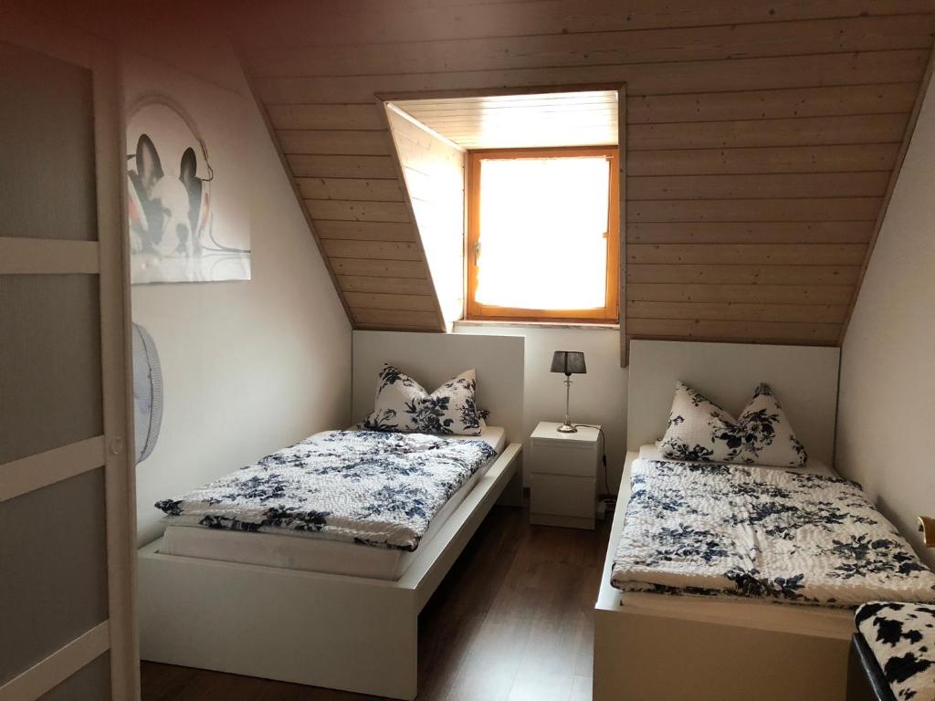 two beds in a small room with a window at Ferienwohnung Held in Erding