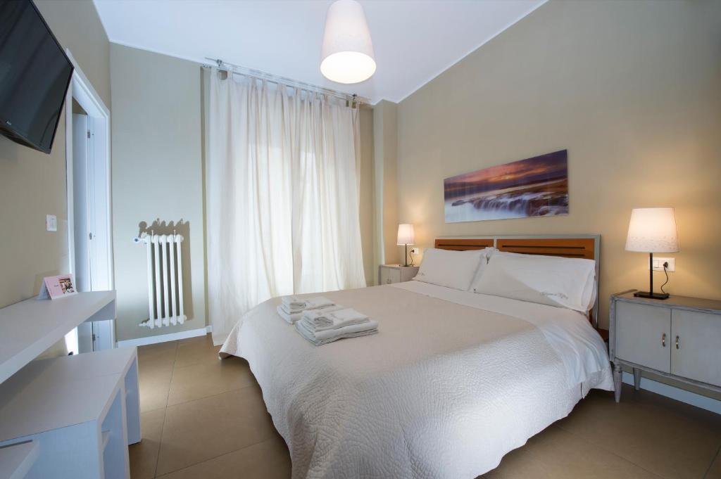 um quarto com uma cama branca e toalhas em Tiffany Rooms em Milão