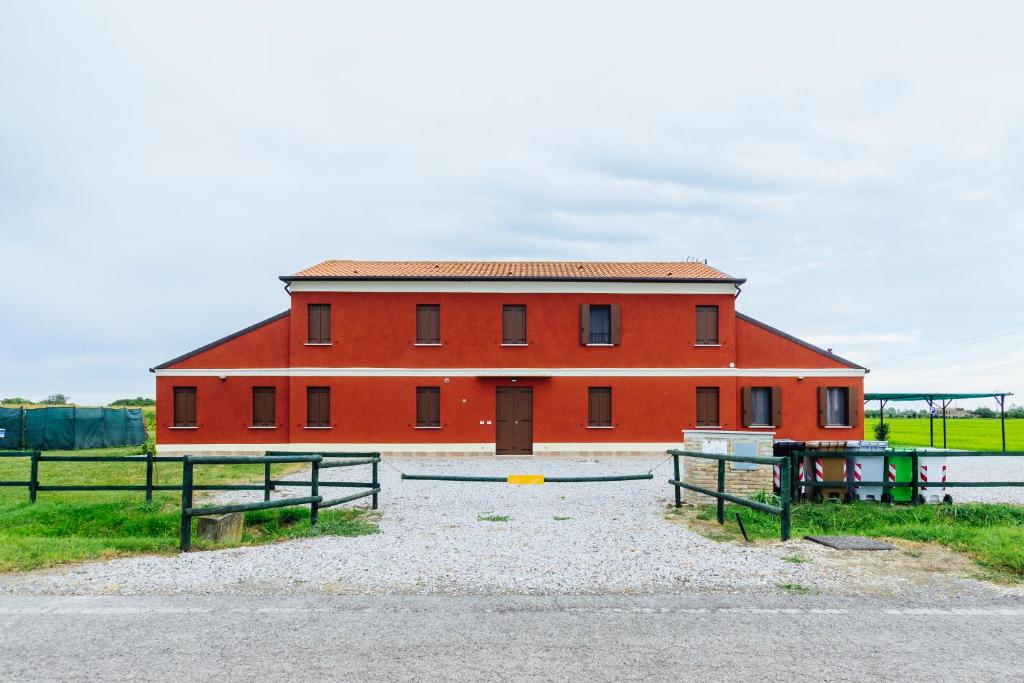 a red barn with two benches in front of it at Agriturismo Cà Vendramin in Ca Vendramin