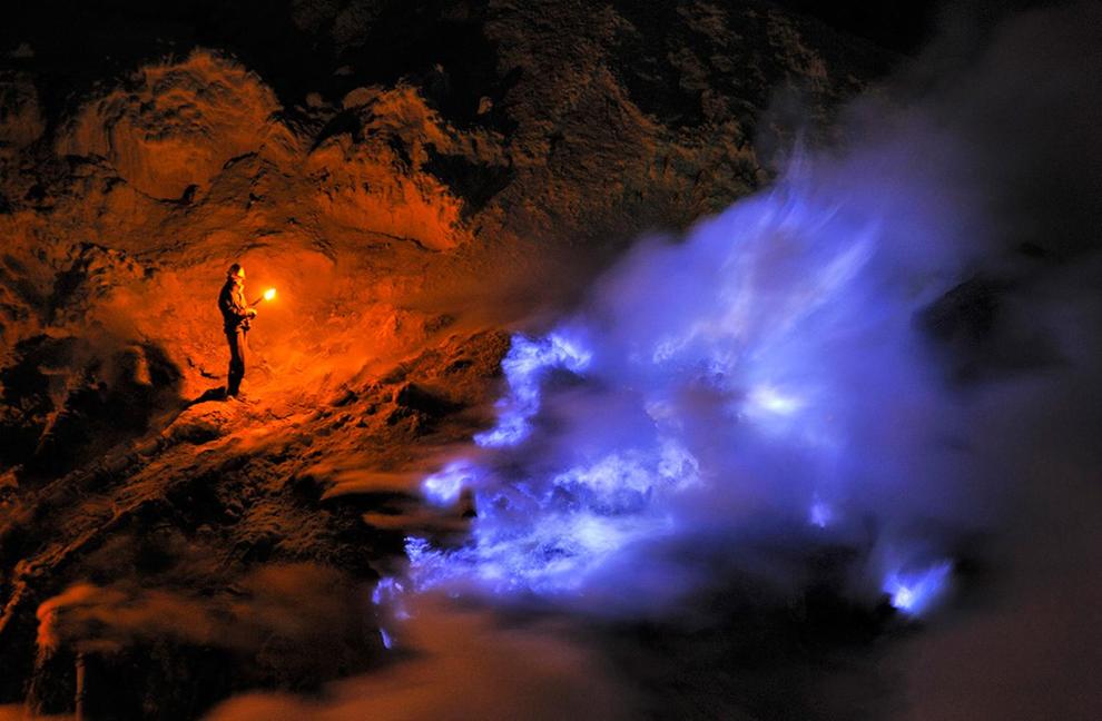 una persona che sta in piedi sopra un vulcano di notte di Sritanjung Homestay a Banyuwangi