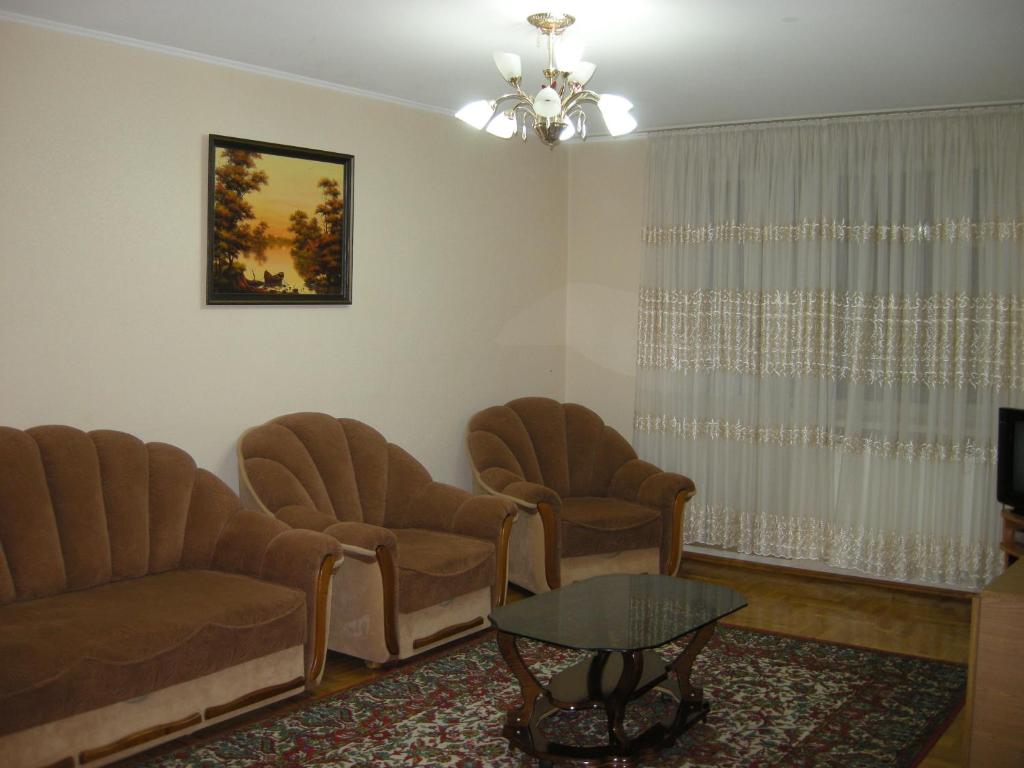 une salle d'attente avec des chaises, une table et une télévision dans l'établissement Apartament in chirie, à Chişinău