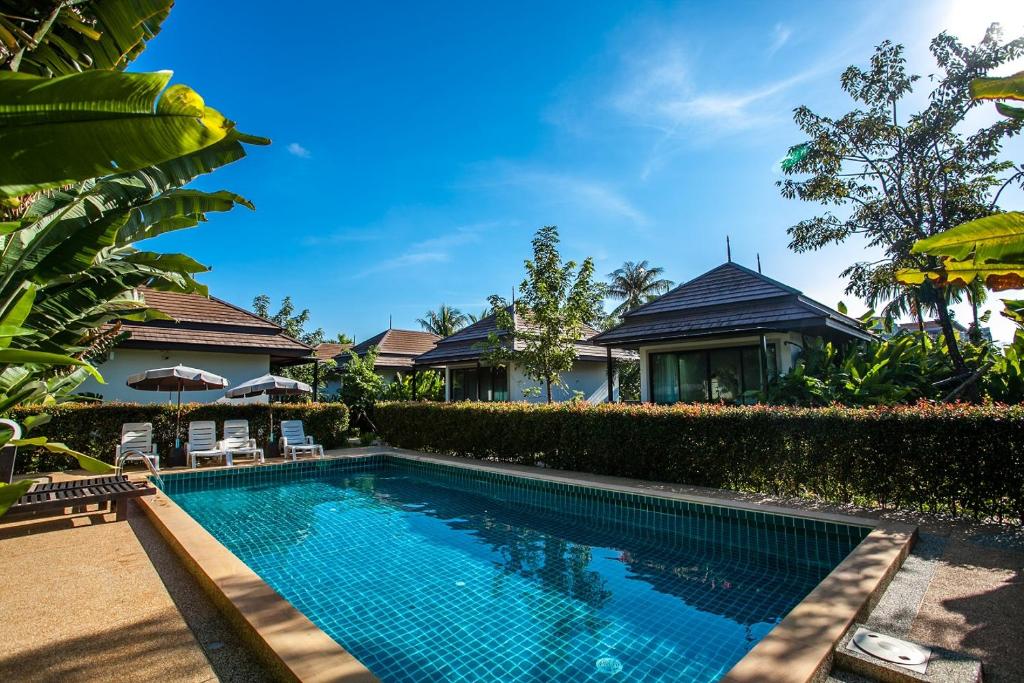 una imagen de una piscina frente a una casa en Himaphan Boutique Resort - SHA EXTRA PLUS en Nai Yang Beach