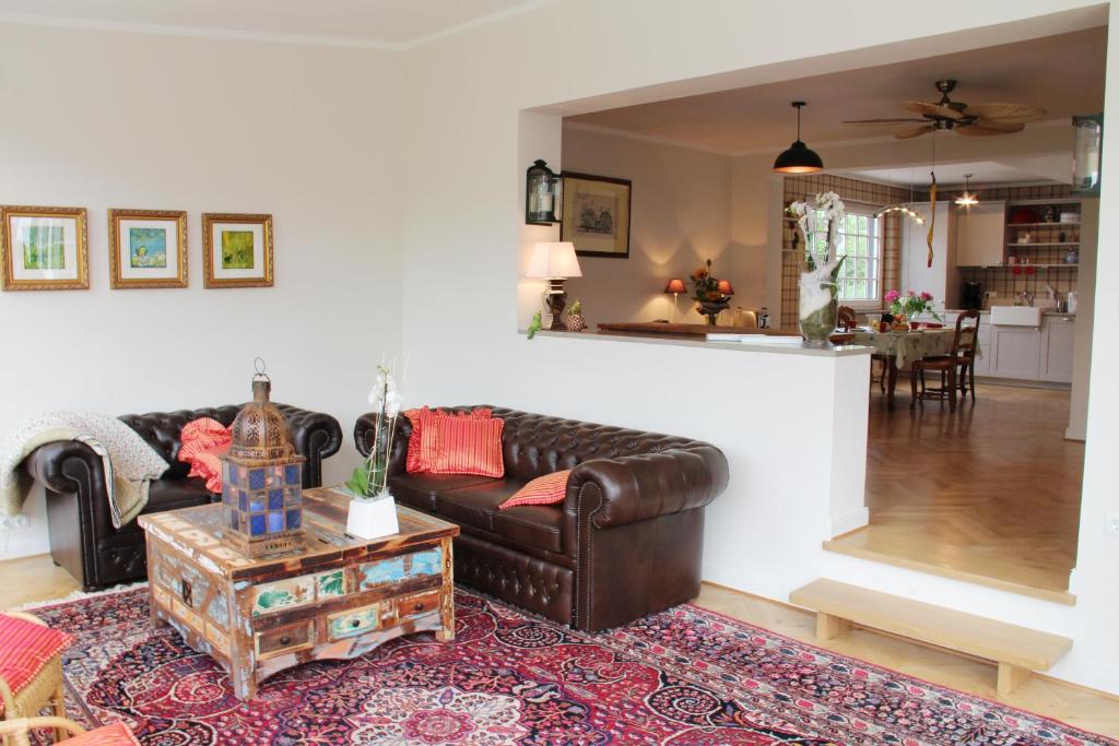 ein Wohnzimmer mit einem Ledersofa und einem Tisch in der Unterkunft Annie's Anker in Bayreuth