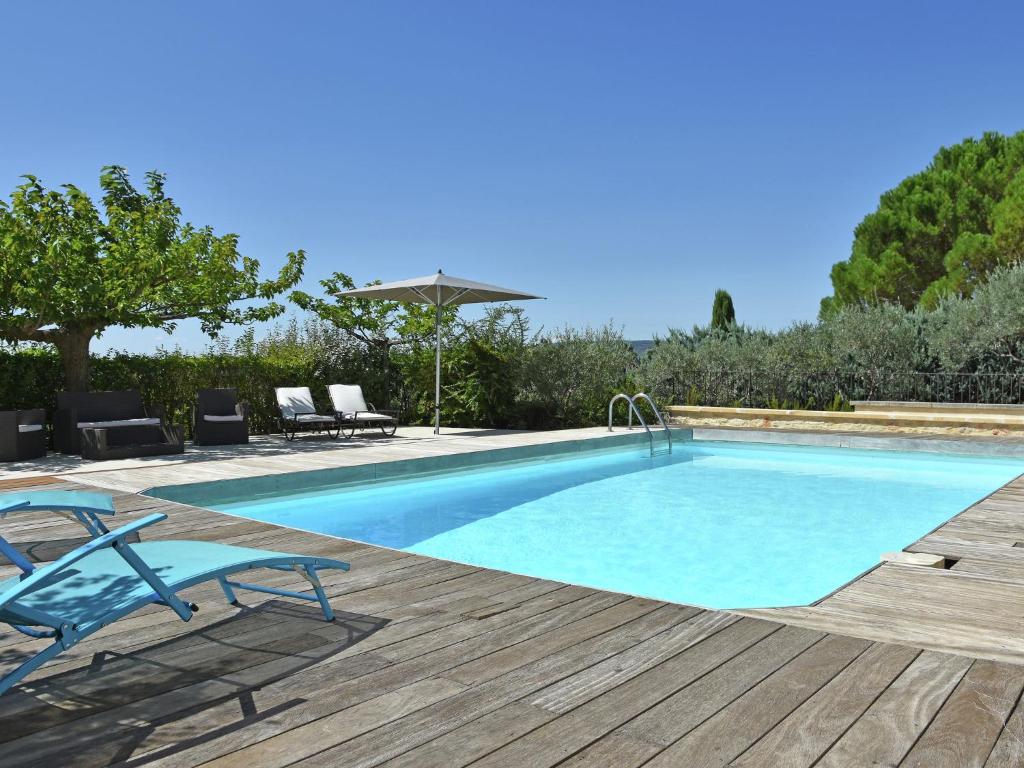 - une piscine avec 2 chaises longues à côté d'une terrasse en bois dans l'établissement Villa in Roussillon with Private Pool, à Roussillon