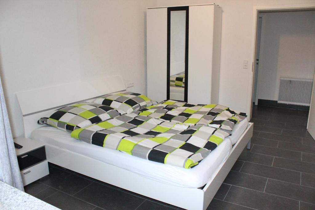 ein Bett mit einer schwarzen und gelben karierten Decke in der Unterkunft Ferienwohnung Albblick 1 Münsingen in Münsingen