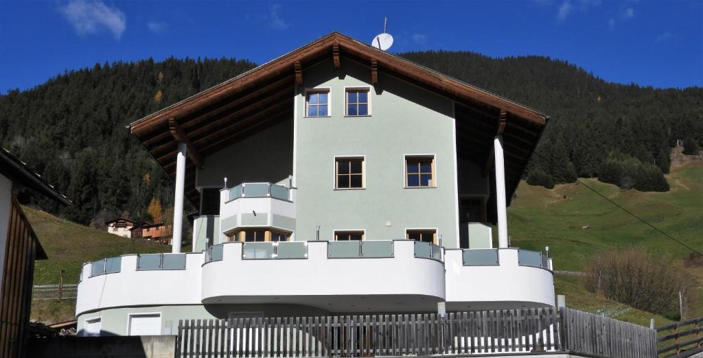 Casa blanca grande con techo marrón en Apart Edi, en Kappl