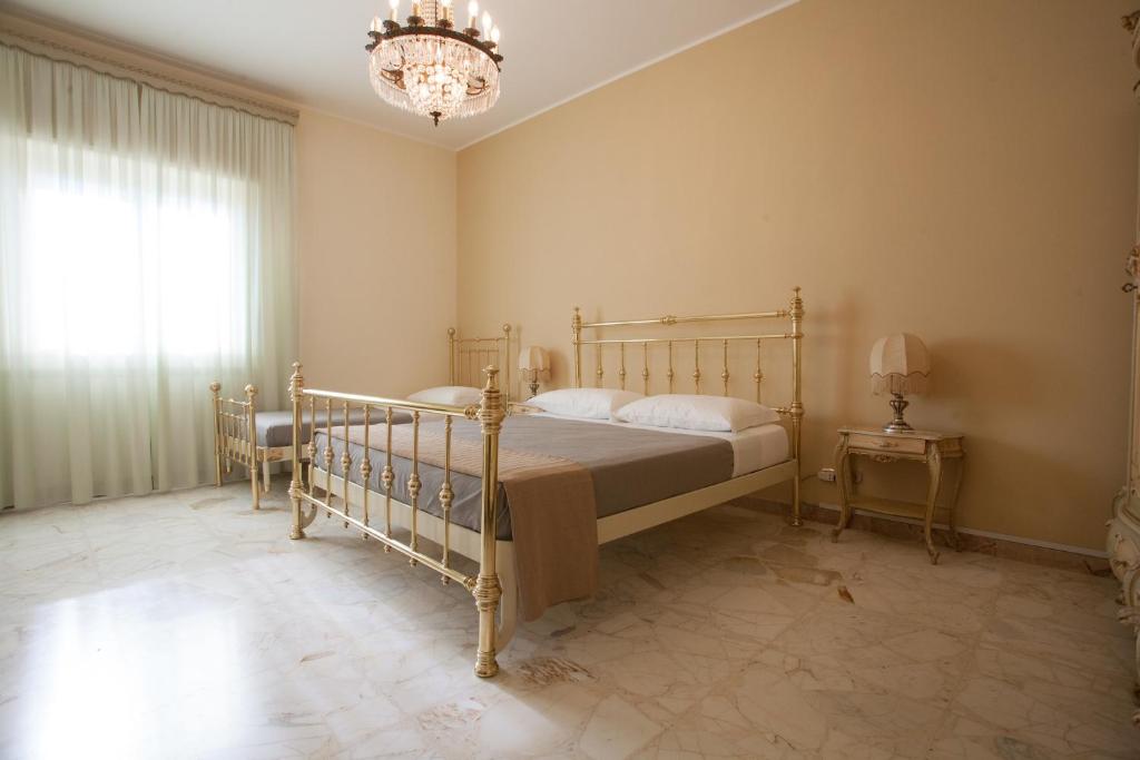 1 dormitorio con cama y lámpara de araña en Settimo Cielo, en Caltagirone