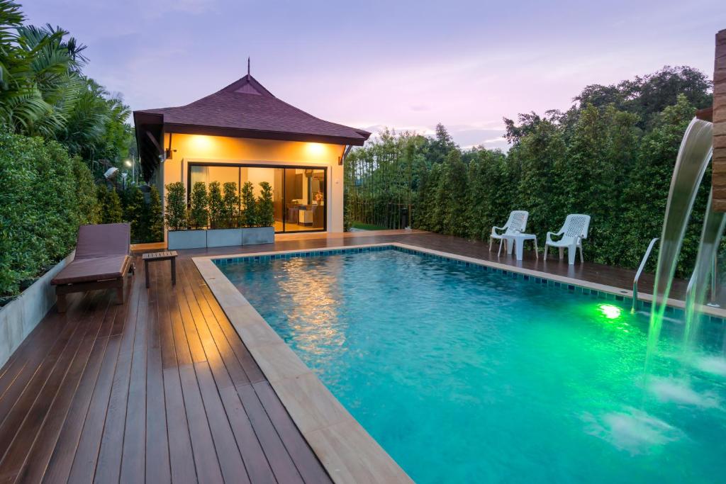 a swimming pool with a deck and a house at Aonang Glory Resort in Ao Nang Beach