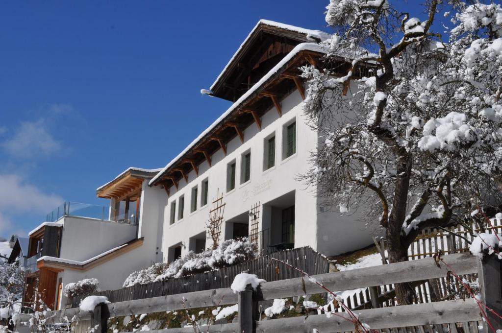 una casa blanca con una cerca en la nieve en Vier Jahreszeiten, en Ladis
