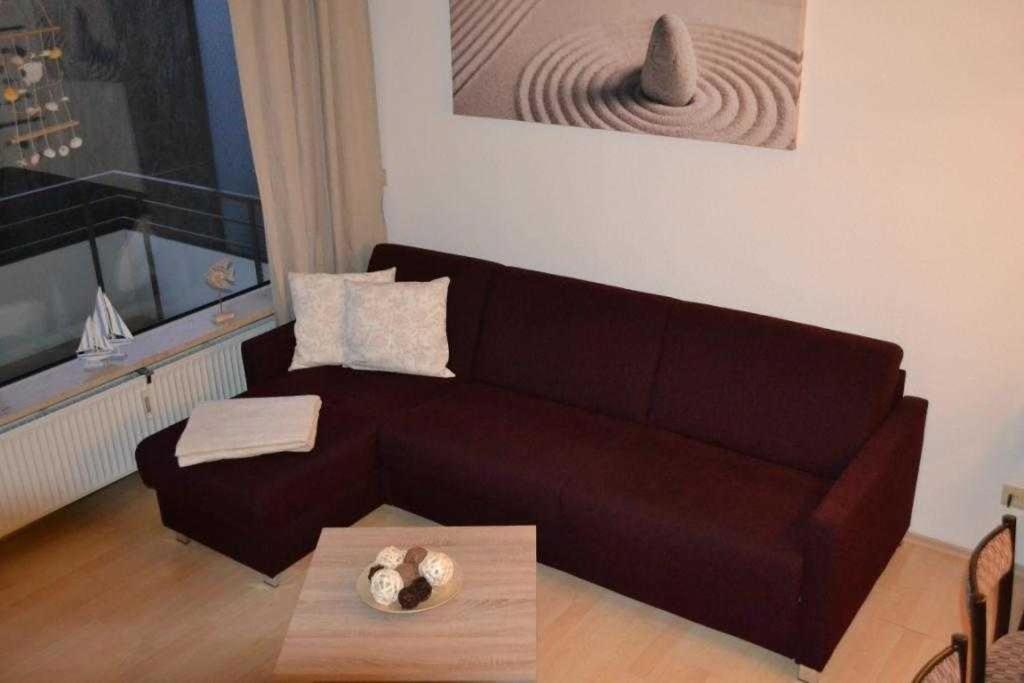a living room with a brown couch and a table at _DKK1e_ Ferienwohnung Seepferdchen in Niendorf