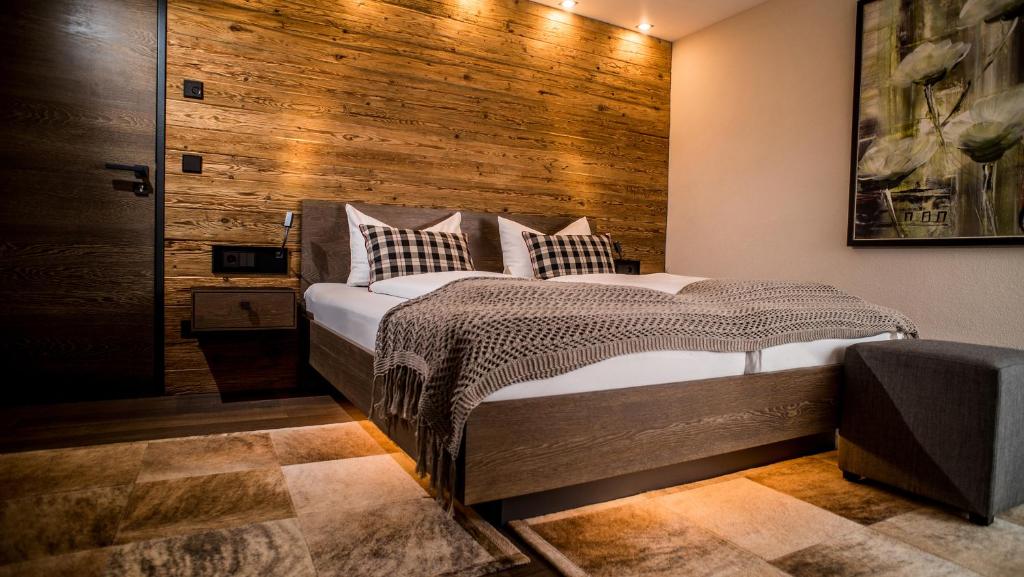 - une chambre avec un lit et un mur en bois dans l'établissement Hotel-Gasthof Adler, à Lindau