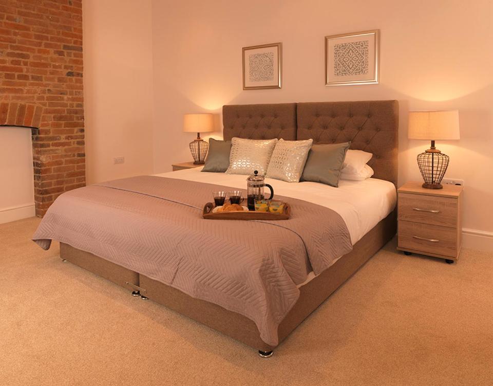 een slaapkamer met een groot bed en een dienblad bij Andover Apartments in Andover