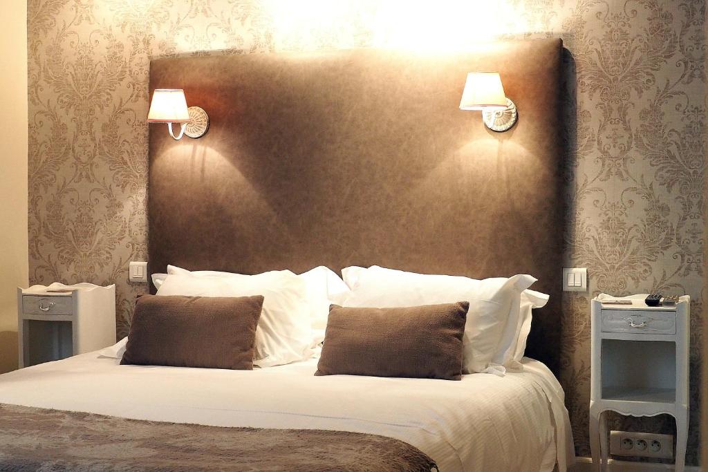 a bedroom with a large bed with two night stands at Louvre Parisian ChicSuites in Paris