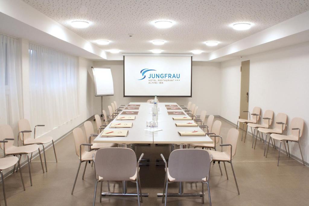 una sala de conferencias con una mesa larga y sillas en Jungfrau Hotel, en Wilderswil