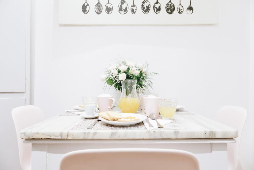 a table with a plate of food and a vase of flowers at Suite Rondanini in Rome