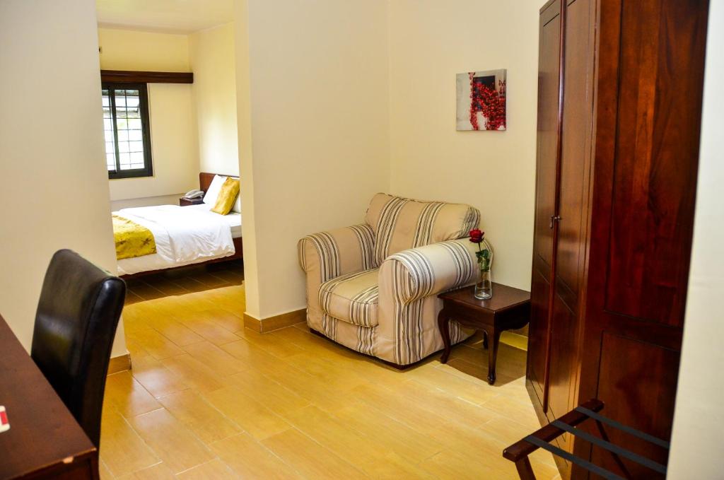 a living room with a chair and a bed at The Cape Hotel in Monrovia