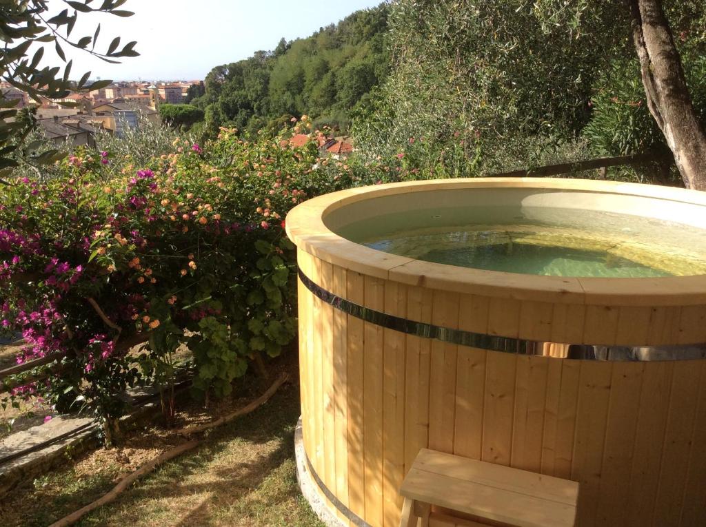 una grande vasca in legno in un giardino fiorito di Olive Press Lodge a Chiavari