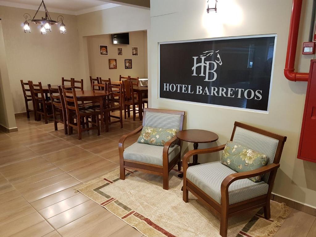 a restaurant with tables and chairs and a large sign on the wall at Hotel Barretos in Barretos