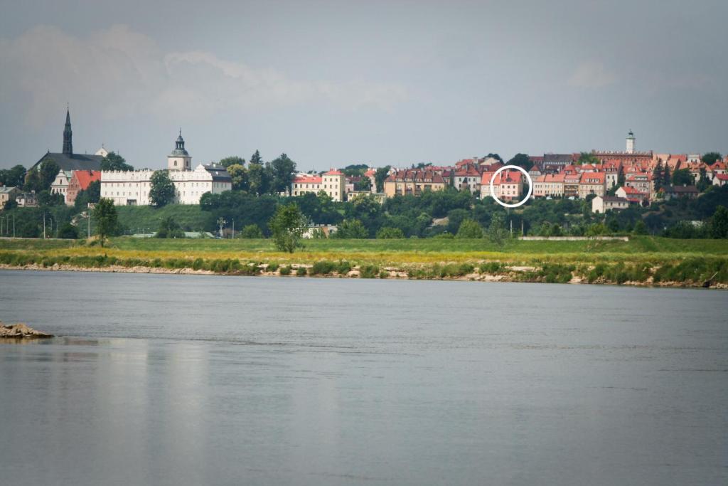 uitzicht op een rivier met een stad op de achtergrond bij Apartament Sandomierskie Wzgórze in Sandomierz