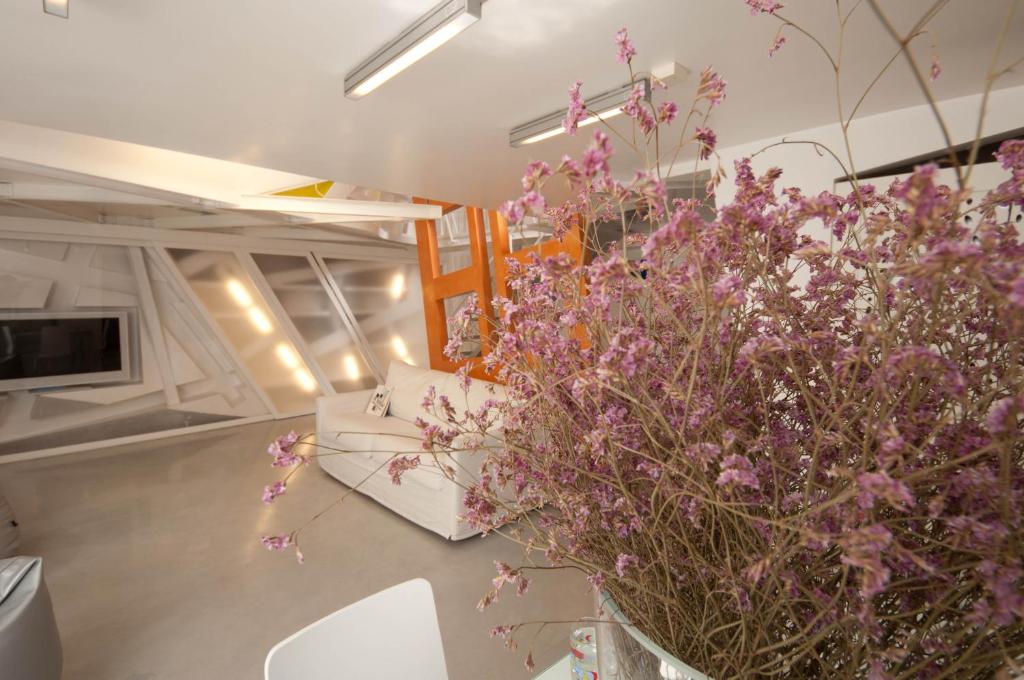 ローマにあるSpace Homeの紫の花が飾られたテーブルが備わる部屋