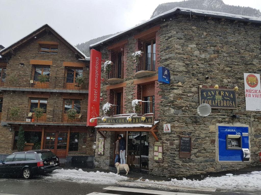 a man standing in the doorway of a stone building at Hotel Comapedrosa in Arinsal