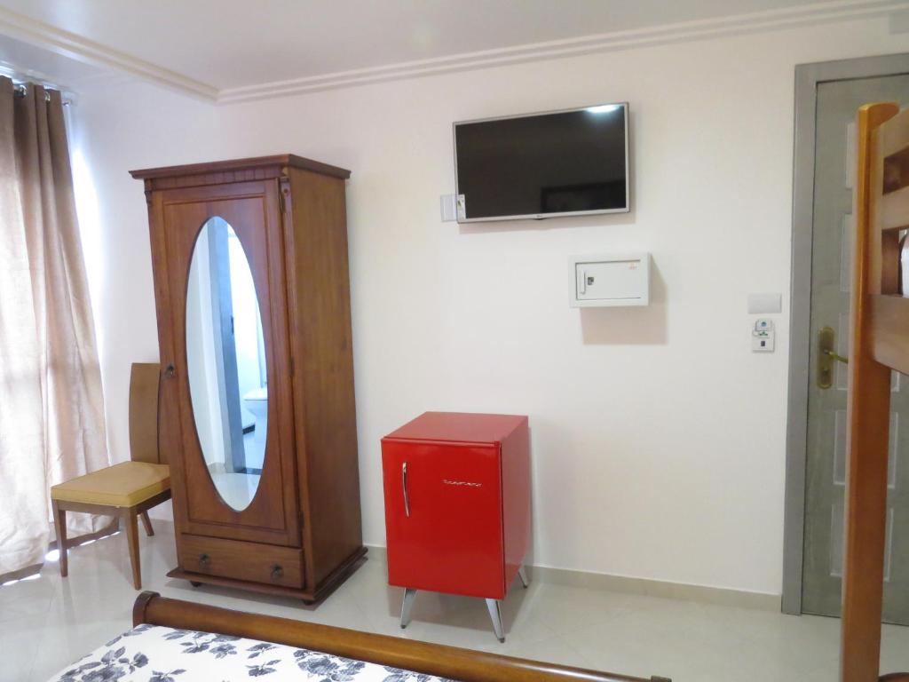Zimmer mit einem Spiegel und einem TV an der Wand in der Unterkunft Pousada Princesa in Arraial do Cabo