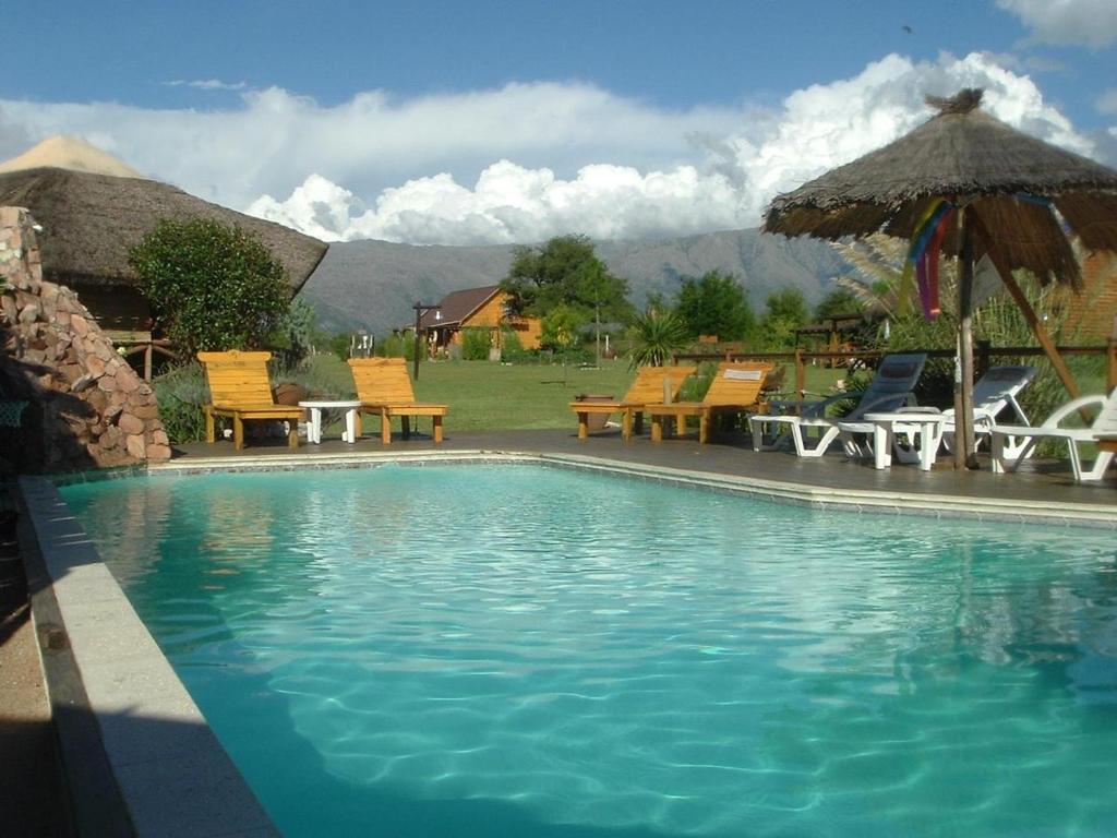 una piscina con sillas y sombrillas en Rancho Paradise - Adults Only en Nono